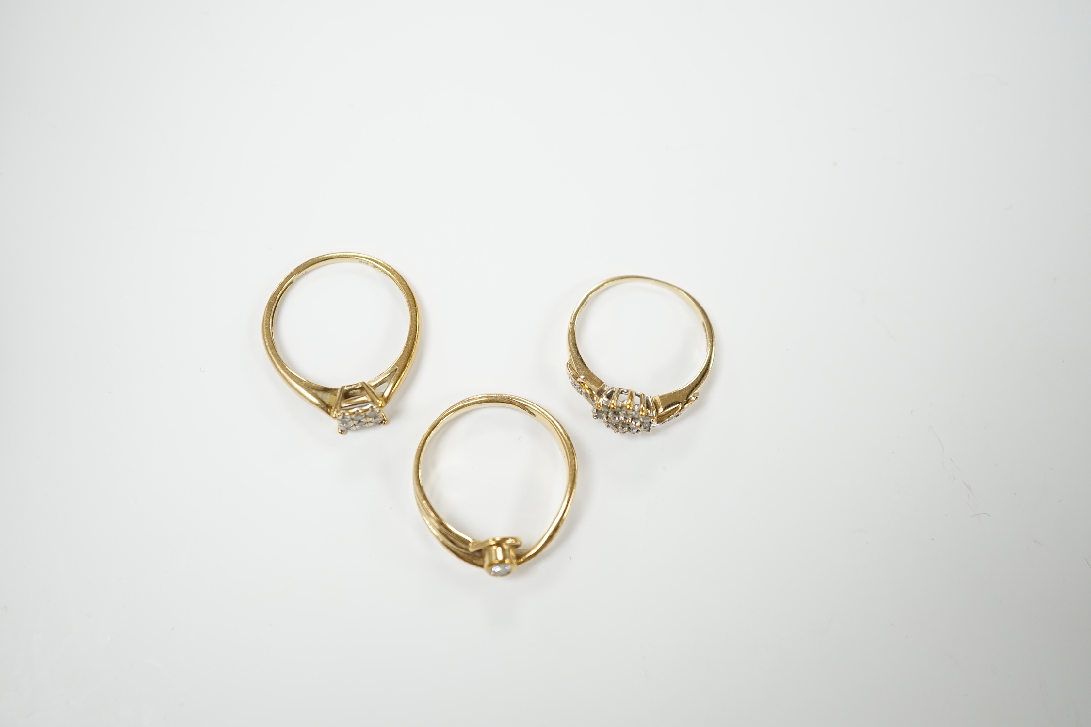 Three modern 9ct gold and diamond set rings, including solitaire and cluster, gross weight 5.9 grams.